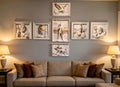 A styled living room featuring a set of seven classical relief sculptures in white frames mounted on a gray wall above a beige sofa with decorative pillows, flanked by two lit table lamps.