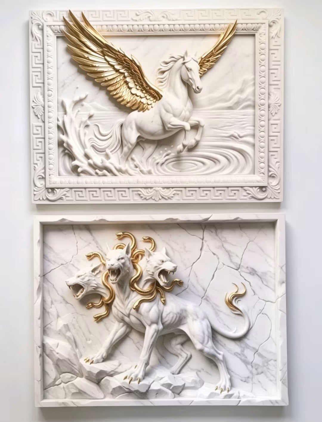 Two framed classical-style relief wall art pieces on a light wall. The top piece shows a white horse with large gold wings, and the bottom piece shows a white multi-headed lion with gold accents, both set in rectangular frames.