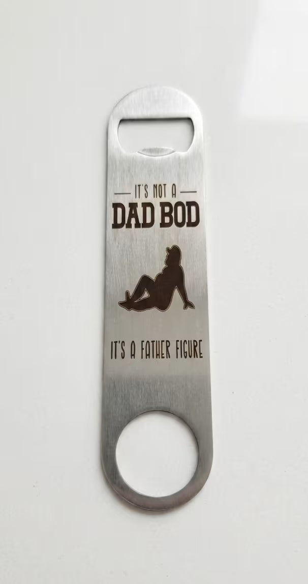 A stainless steel bottle opener with a black printed graphic and the text 'IT'S NOT A DAD BOD' and 'IT'S A FATHER FIGURE' on a plain white background.