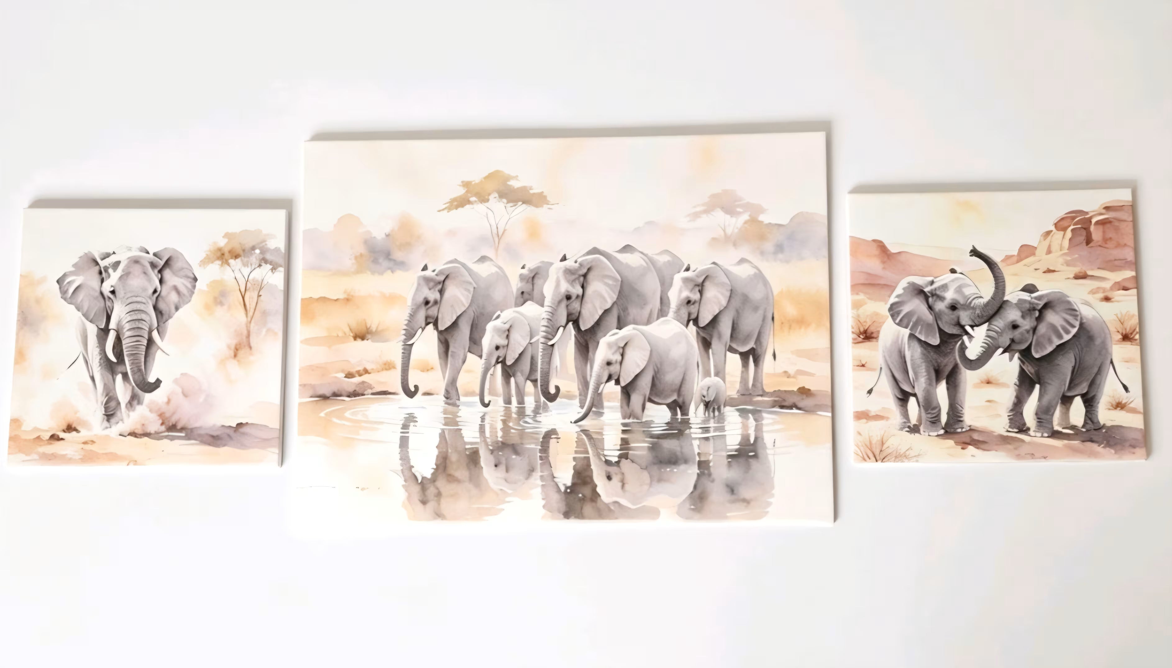 Three-piece wall art set featuring watercolor paintings of elephant families in a savanna landscape, displayed on a white wall.