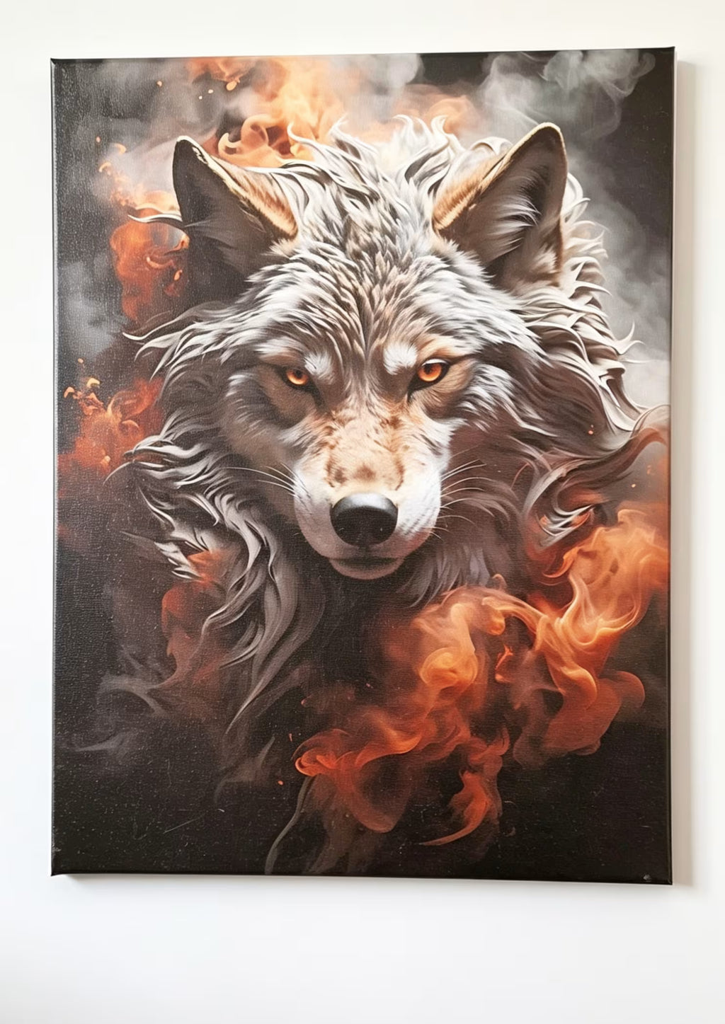 A vertical canvas wall art print depicting a detailed portrait of a wolf surrounded by dramatic orange flames and dark smoke on a black background, shown hanging on a white wall.