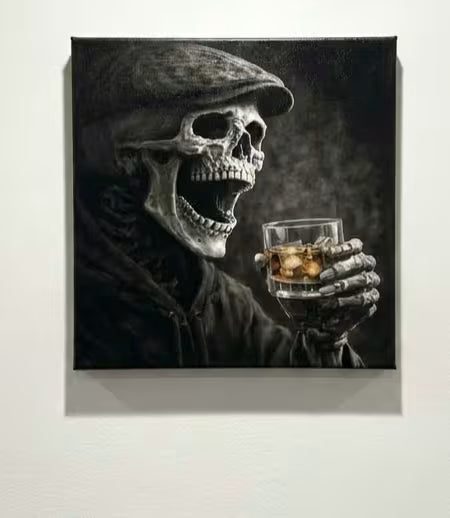 A square black and white canvas wall art print depicting a skeletal figure in a flat cap holding a glass of amber liquor, mounted on a light gray wall.